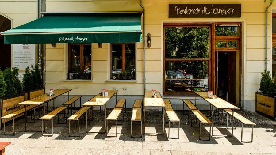 Das Rembrandt Burger in Berlin von außen, mit Bänken auf dem Gehweg